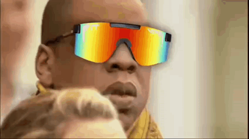 A Man Wearing A Pair Of Colorful Sunglasses Is Looking At A Woman . GIF