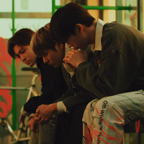 A Man Wearing A Pair Of Off White Pants Sits On A Bench GIF