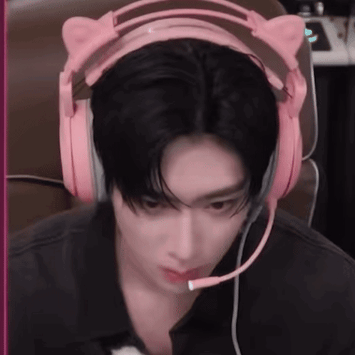 A Man Wearing A Pair Of Pink Headphones With A Microphone . GIF