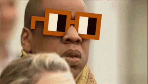 A Man Wearing A Pair Of Square Glasses With The Letter H On It GIF