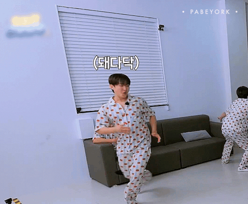 A Man Wearing A Pajama Shirt With Strawberries On It Is Laughing GIF