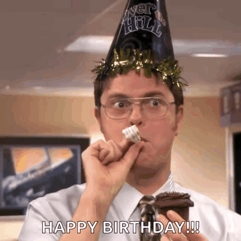 a man wearing a party hat is eating a piece of cake and saying happy birthday ..