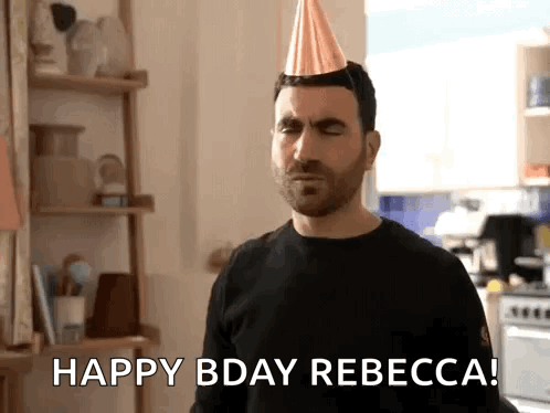A Man Wearing A Party Hat Is Standing In A Kitchen And Saying Happy Bday Rebecca . GIF