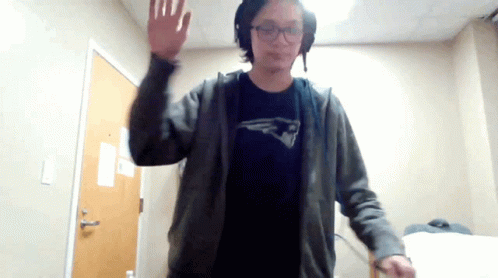 A Man Wearing A Patriots Shirt Is Waving At The Camera GIF