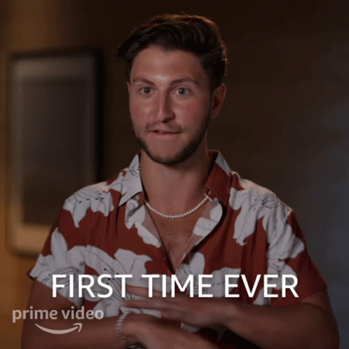 A Man Wearing A Pearl Necklace And A Shirt That Says First Time Ever GIF