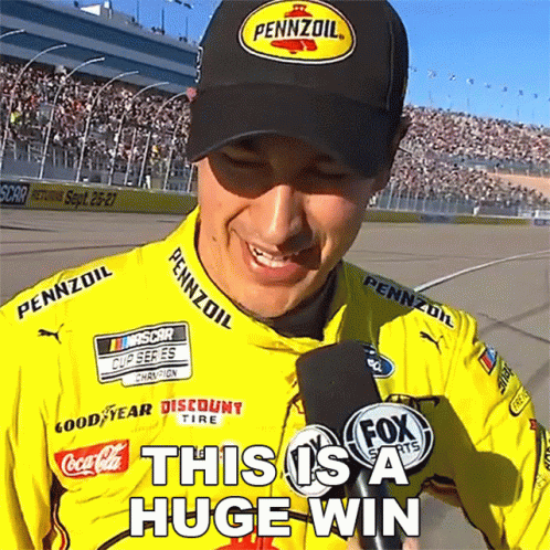 A Man Wearing A Pennzoil Hat Is Smiling While Holding A Microphone GIF