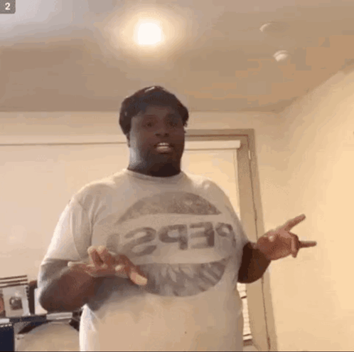 A Man Wearing A Pepsi T-Shirt Is Standing In A Room GIF