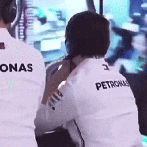 A Man Wearing A Petronas Shirt Is Sitting In Front Of A Monitor GIF