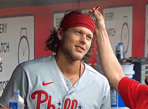 A Man Wearing A Phillies Jersey Is Getting His Hair Brushed GIF