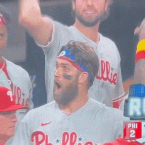 A Man Wearing A Phillies Jersey Stands In The Stands GIF