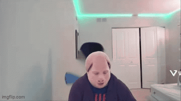 A Man Wearing A Pig Mask Is Standing In A Room With A Green Light On The Ceiling . GIF