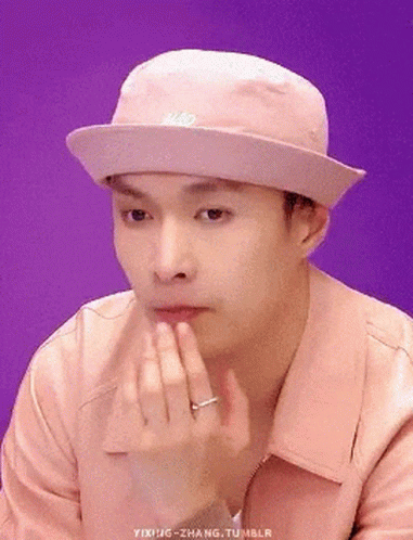 Man In Pink Hat And Jacket Holding Chin GIF