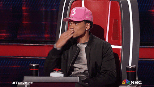 A Man Wearing A Pink Hat With The Number 3 On It Sits In A Chair GIF