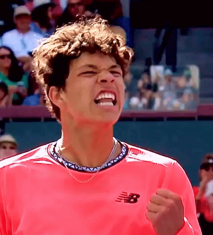A Man Wearing A Pink New Balance Shirt Is Celebrating GIF