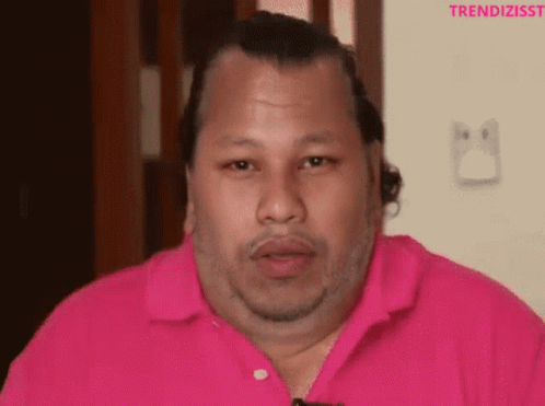 A Man Wearing A Pink Shirt With The Word Trendizisst On The Bottom Right GIF