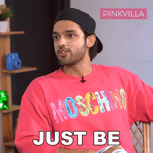 A Man Wearing A Pink Sweatshirt That Says Moschino On It GIF