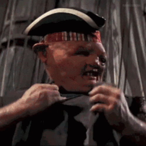 A Man Wearing A Pirate Hat Is Pulling His Shirt Up GIF