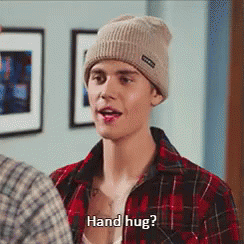 A Man Wearing A Plaid Shirt And A Beanie Is Asking For A Hand Hug GIF