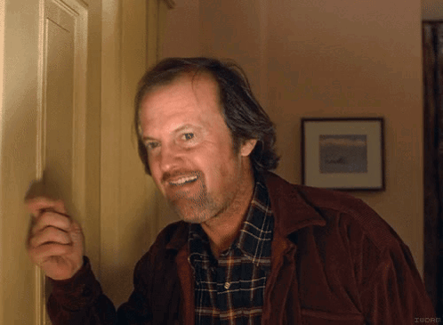 A Man Wearing A Plaid Shirt And A Brown Jacket Is Smiling GIF