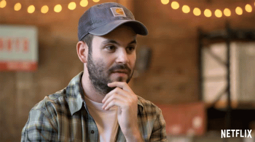 Man In Plaid Shirt And Carhartt Hat Sitting In Front Of Netflix GIF