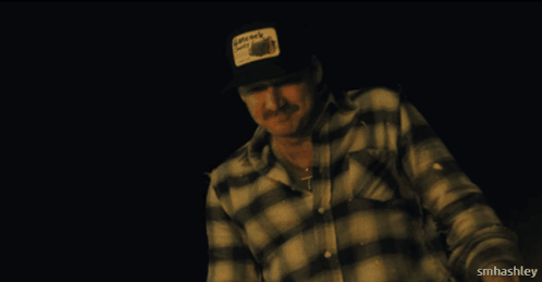 A Man Wearing A Plaid Shirt And A Hat That Says Little Rock City On It GIF