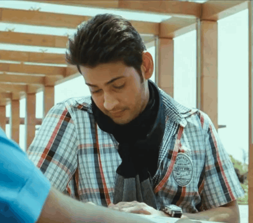 A Man Wearing A Plaid Shirt Has A Badge On His Sleeve That Says ' Sydney ' On It GIF