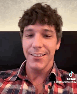 a man wearing a plaid shirt is smiling for the camera .