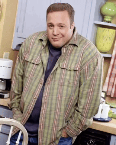A Man Wearing A Plaid Shirt Is Standing In A Kitchen GIF