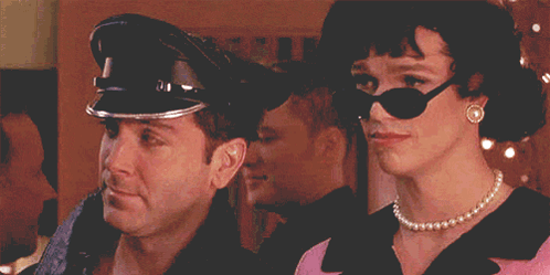 A Man Wearing A Police Hat And A Woman Wearing Sunglasses GIF