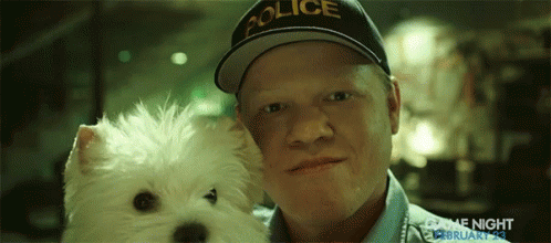 A Man Wearing A Police Hat Holds A White Dog GIF