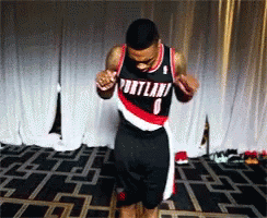 A Man Wearing A Portland Jersey Is Dancing On A Stage GIF