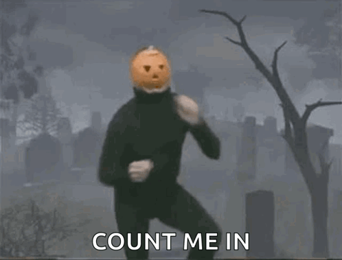 A Man Wearing A Pumpkin Mask Is Dancing In A Cemetery . GIF