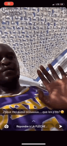 A Man Wearing A Purple And Yellow Lakers Jersey Is Waving His Hand GIF