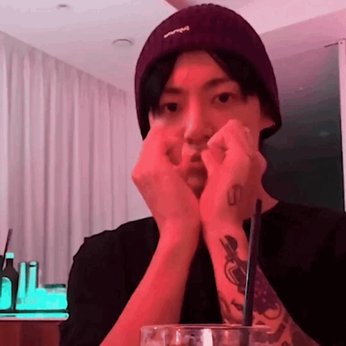 a man wearing a purple beanie has a tattoo on his left wrist