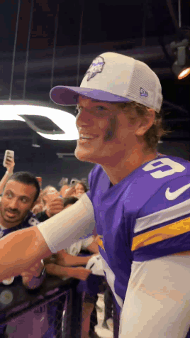 A Man Wearing A Purple Jersey With The Number 9 On It Shakes Hands With A Fan GIF