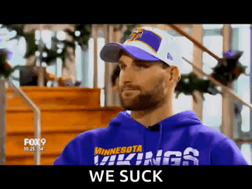 A Man Wearing A Purple Minnesota Vikings Sweatshirt And Hat GIF