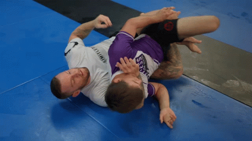 A Man Wearing A Purple Shirt That Says Samurai Is Wrestling Another Man GIF