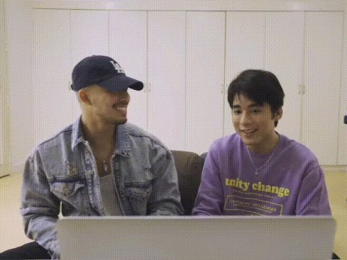 a man wearing a purple shirt that says unity change sits next to another man