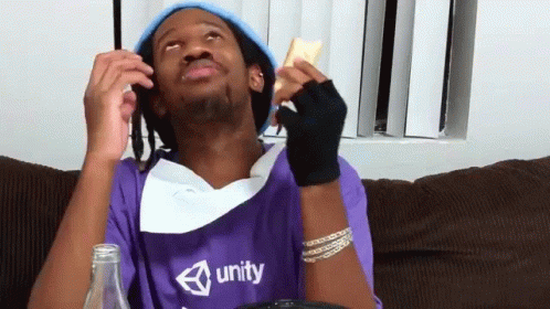 A Man Wearing A Purple Shirt That Says Unity Is Sitting On A Couch GIF