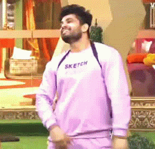 a man wearing a purple sweater with the word sketch on it is dancing .