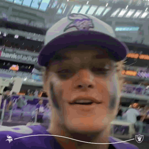 A Man Wearing A Purple Vikings Hat Is Smiling In A Stadium GIF