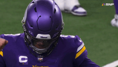 A Man Wearing A Purple Vikings Jersey With The Number 8 On It GIF
