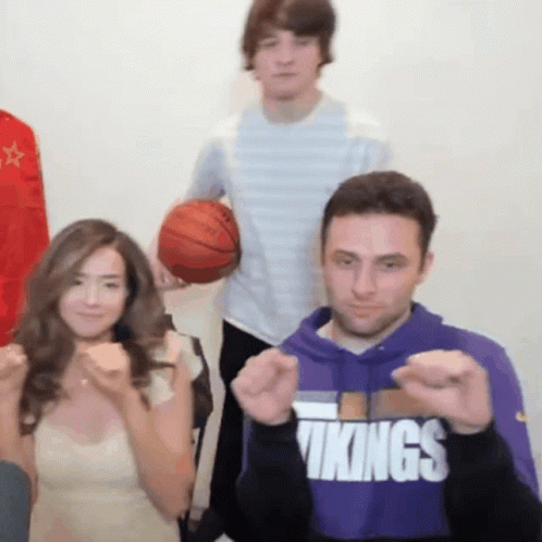 A Man Wearing A Purple Vikings Sweatshirt Is Making A Fist GIF