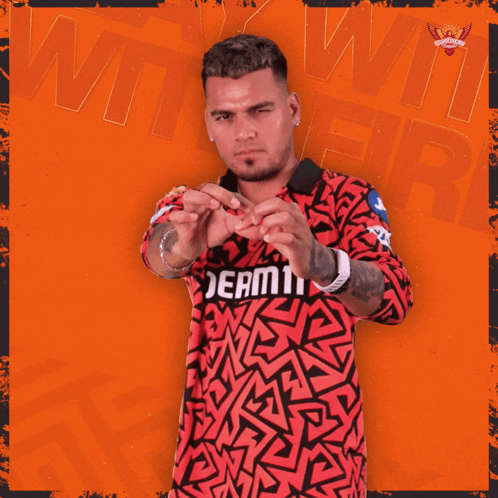 a man wearing a red and black shirt that says dream11 on it