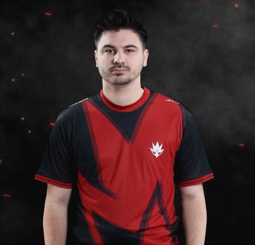 A Man Wearing A Red And Black Shirt With A White X On The Sleeve GIF