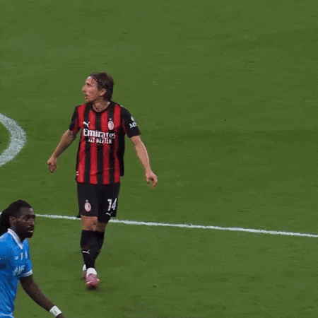 A Man Wearing A Red And Black Striped Shirt With Fly Emirates On The Front GIF