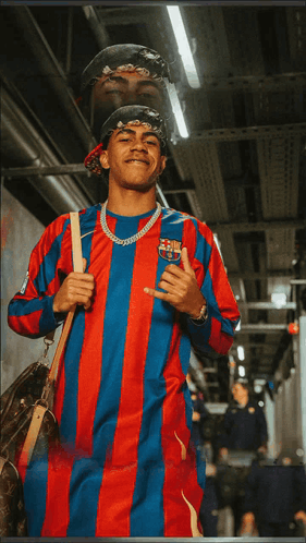a man wearing a red and blue striped shirt with a fcb logo on it