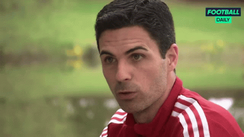 A Man Wearing A Red And White Adidas Shirt Is Looking At The Camera GIF