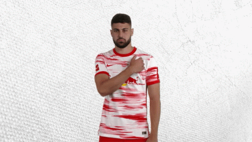 a man wearing a red and white jersey with a red bull on the front