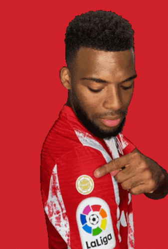 A Man Wearing A Red And White Laliga Jersey Points At His Arm GIF
